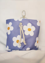Purple pouch with white daisy patterns on a light background