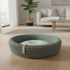 Coco Basket green hand-woven cotton rope dog bed centered on light oak floor in sunlit modern living room